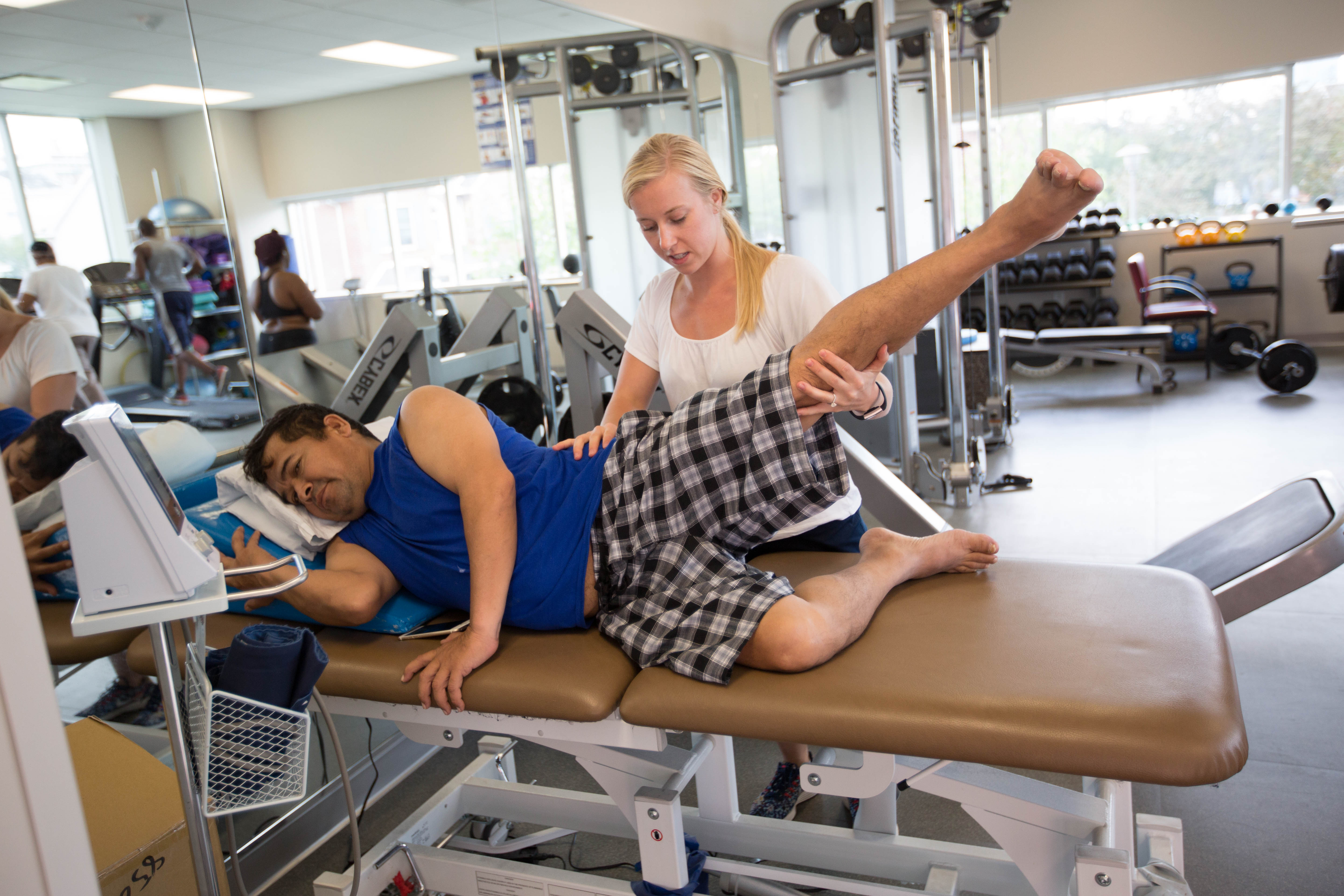 A physical therapy works with a patient on a table